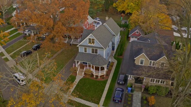 Autumn scene with residential home aerial pull away, showing street and neighborhood. 