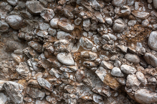 Background texture from stones in crumbling rock. Horizontal image.