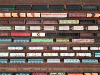 Cargo trains close-up. Aerial view of colorful freight trains on the railway station. Wagons with...