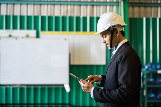 Smiling Factory manager using tablet to check stock