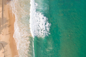 Aerial view sandy beach and waves Beautiful tropical sea in the morning summer season image by Aerial view drone shot High angle view Top down.