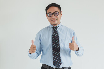 Smiling sales man wearing blue shirt, tie and glasses posing with thumb up on white background