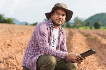 Smart farmer using a technology for studying and development agricultural. The farmer using tablet for tests the growth quality of seedling.