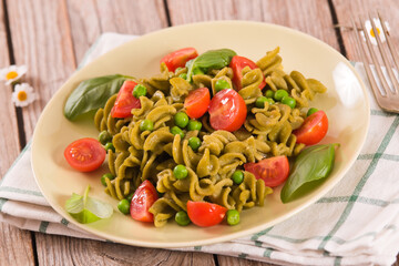 Fusilli pasta with cherry tomatoes and peas.