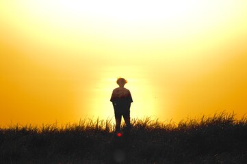 silhouette of a person walking on a meadow