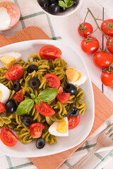 Fusilli pasta with cherry tomatoes, eggs and black olives.