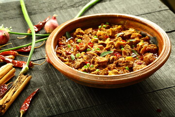 Traditional Indian cooking- tasty and spicy beef curry roast cooked in clay pottery.