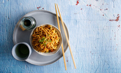 Japanese food , vegetable noodles in Teriyaki sauce served in a bowl with chopsticks on the side.
