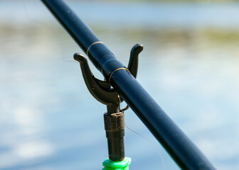 landscape with a lake, fishing on the lake shore, calm water surface with trees and sky reflections, the first greenery on the lake shore