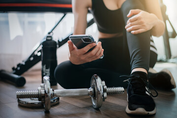 Close up of woman using smart phone workout in home. Sport and Technology concept. Lifestyles and Healthcare theme.