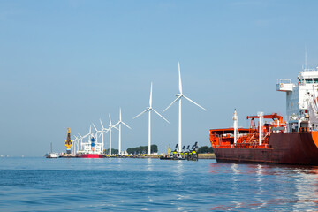 A seaport on the outskirts of Amsterdam with wind generators on the coast and solar panels mounted...