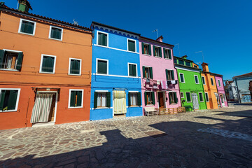Beautiful houses with bright colors (multi coloured) in Burano island in a sunny spring day with clear sky. Venice lagoon, UNESCO world heritage site, Veneto, Italy, southern Europe.