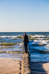 woman walking on the breakwater on the beach in Leba.