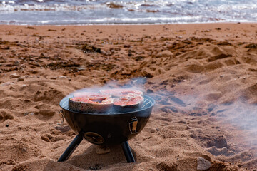 Salmon steaks are grilled. Cooking fish on coals by the sea 