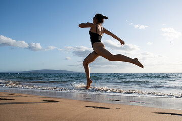 Fototapeta na wymiar Woman running on beach in morning. Fitness workout sport outdoor.