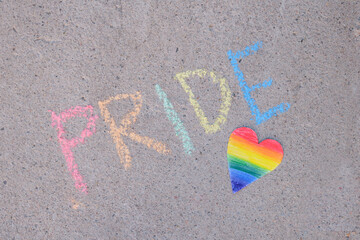 paper heart painted in rainbow colors lgbt community pride inscription in chalk on asphalt, pride month concept