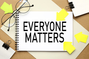 Everyone Matters. inscription on a notebook on a craft and gray background