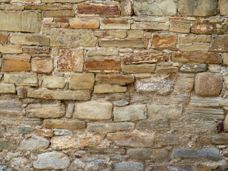 Texture rubble masonry made of uneven stone bricks. Background of the wall of the historical castle in the Crimea. Yellow brickwork of the fortress ruins.