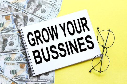 grow your business. background with money, dollar bills and yellow background. text on notepad