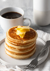 Breakfast with cup of coffee and fluffy pancakes with  butter .