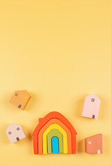 Rainbow flag colors toy house and small pastel color wooden houses on yellow background