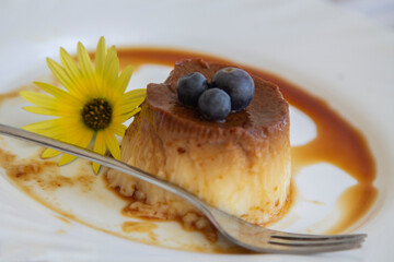 delicious flan with caramel and blueberries on the plate