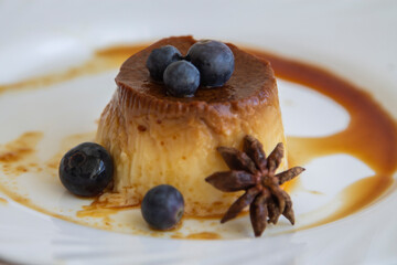 delicious flan with caramel and blueberries on the plate