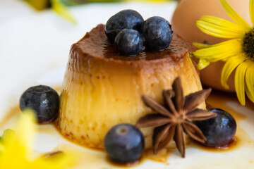 delicious egg custard with caramel and blueberries on the plate
