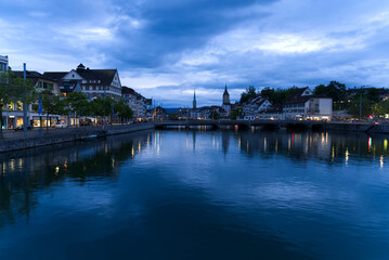 Fototapeta premium Old town of Zurich with river Limmat and churches St. Peter and Fraumünster (Women's minster) at Saturday night at summertime. Photo taken June 5th, 2021, Zurich, Switzerland.