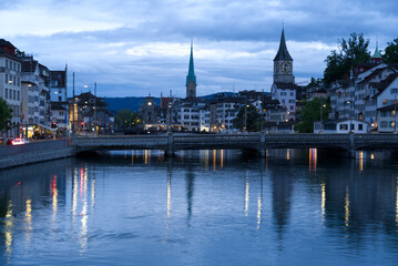 Fototapeta premium Old town of Zurich with river Limmat and churches St. Peter and Fraumünster (Women's minster) at Saturday night at summertime. Photo taken June 5th, 2021, Zurich, Switzerland.