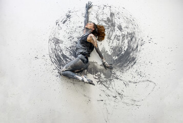 Young woman in gray shirt lies dancing dances on the floor elegantly decorative. Creative, abstract expressive body art and painting.