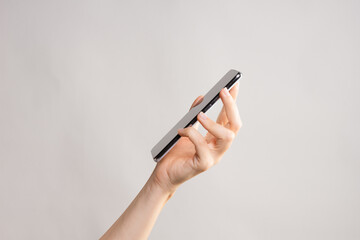 Slim modern smartphone in a woman's hand, use the Internet or apps on your phone.