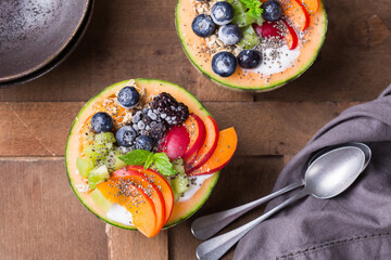 Fruit salad with yogurt in carved melon cantaloupe bowl