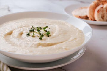 Closeup view of white bowl with mushroom cream soup - healthy food concept. Classic recipe. Selective focus