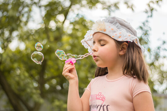 little girl blowing soap bubbles