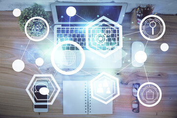 Social network hologram drawings over computer on the desktop background. Top view. Multi exposure. Concept of people connection.