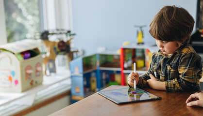Boy drawing on digital tablet at home