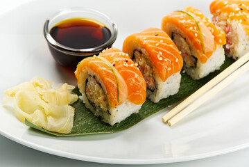 Sushi and soy sauce in a white bowl and white wooden chopsticks white table. Japanese food. Japanese seafood Sushi Set. Sushi bar Menu. isolated