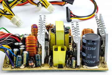 An open computer power supply at 220 volts with visible electronic components on the printed...