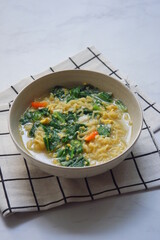 a bowl of noodle soup with vegetables