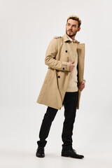 handsome man in beige coat autumn style studio full growth side view