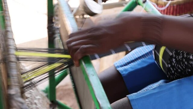 Woman at loom making kente material northern Ghana HD. Where the traditional cloth in Africa, Kente is made on hand looms, hand woven. The Kente is worn by the king of the Ashanti Kingdom.