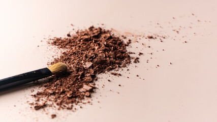 broken eye shadow scattered across the smooth pink surface. Texture background, advertising the structure of cosmetics. macro, copyspace