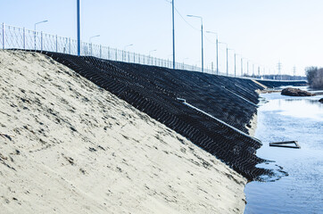 Industrial geocells in operation. Black geogrid filled with soil for stability of steep hill
