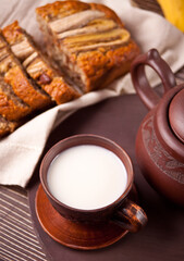 Clay tea cup with teapot on old wooden table