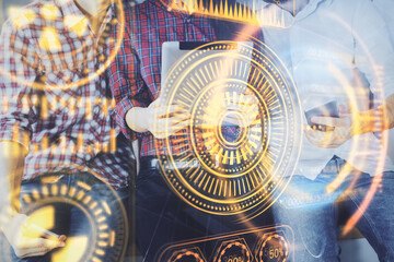 Double exposure of tech theme hologram and man and woman working together holding and using a mobile device.
