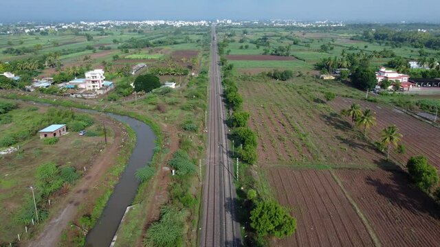 Aerial footage of a mainline Electric Multiple Unit or MEMU train of the Indian Railways at Uruli near Pune India.