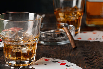 Playing poker with whiskey and cigars on table