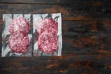 Burger meat vacuum sealed ready for sous vide cooking, on old dark  wooden table background, top...