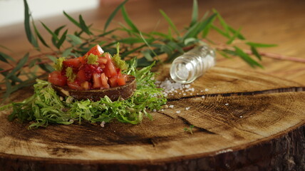 Bruschetta mit Salat auf einem Holzbrett
